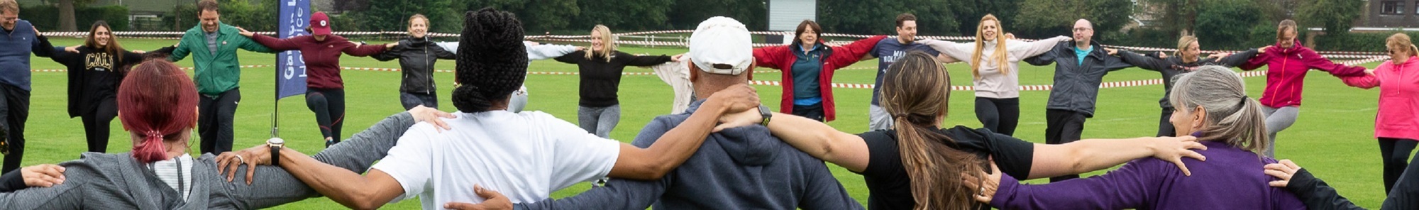 Team-arm-in-arm-at-team-building-day